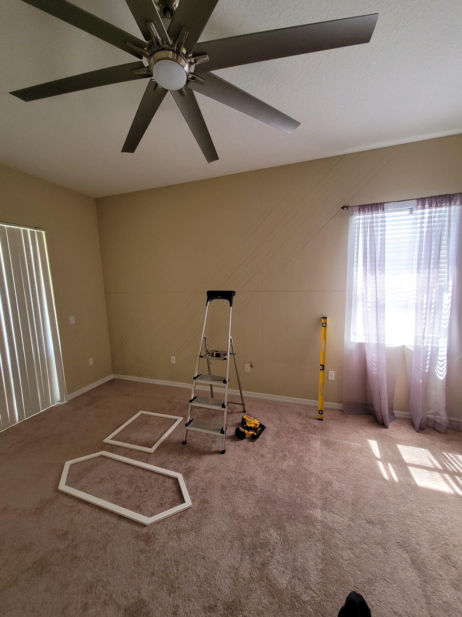 Empty bedroom with old carpet and bare walls before renovation