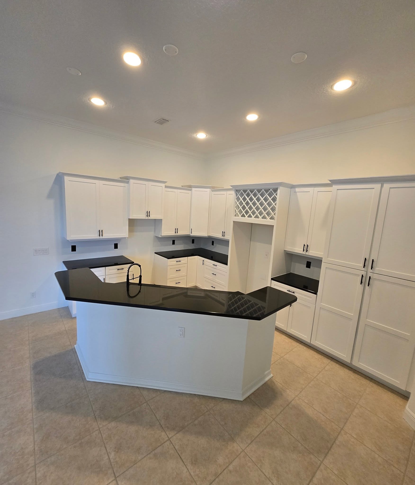 Kitchen after with bright white painted cabinets and new hardware
